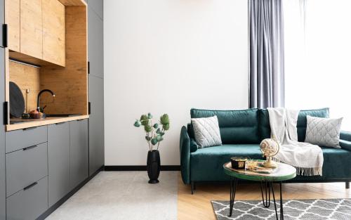 a living room with a green couch and a table at Wrota Chałubińskiego in Zakopane
