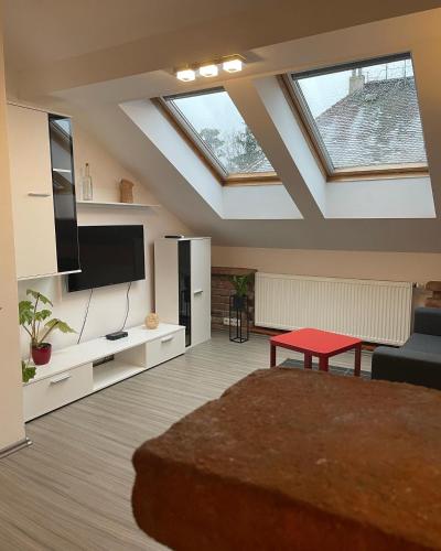 a living room with a skylight and a red table at Penzion Královské lázně in Poděbrady