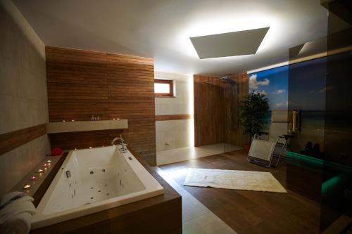 a large bathroom with a tub in a room at Beskid Rose & SPA in Słopnice