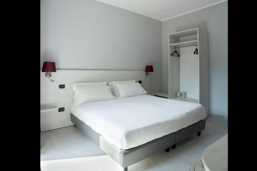 biała sypialnia z białym łóżkiem i stołem w obiekcie Hotel Pone w mieście Sesto San Giovanni