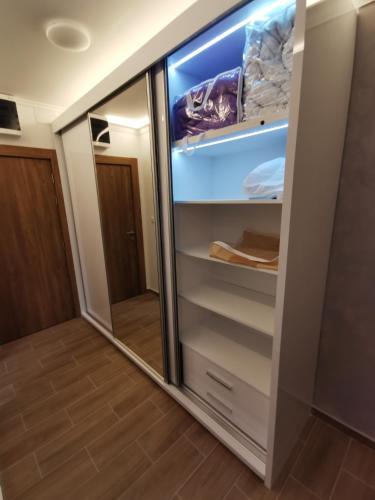 a walk in closet with a glass door at Suncana planina apartman 103 in Kopaonik