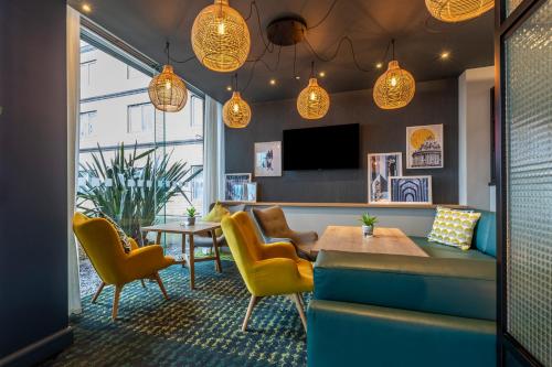 a waiting room with chairs and a table and a tv at Holiday Inn Oxford by IHG in Oxford