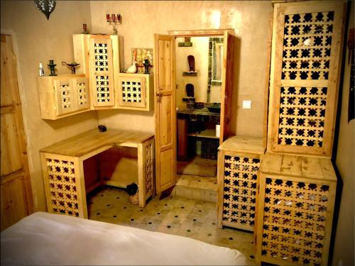 a bathroom with wooden cabinets and a sink at Maison d'hôte ''J'' in Agdz