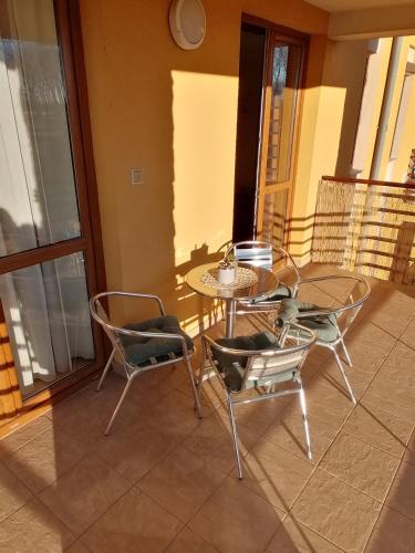 a patio with a table and chairs on a balcony at Beatrix Apartments in Bük