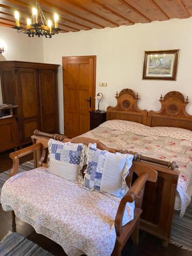 a bedroom with two beds and a bench in it at Öregház 1839 in Csopak