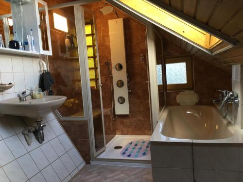łazienka z prysznicem, wanną i umywalką w obiekcie Aktiv pihenés apartman w mieście Révfülöp