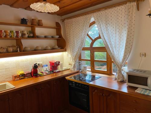 a kitchen with a window and a stove top oven at Öregház 1839 in Csopak