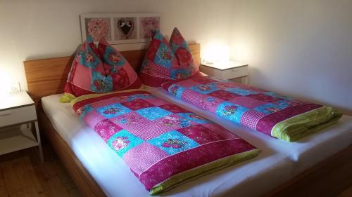 a bed with two blankets and pillows on it at Ferienwohnung Holiday Lienz in Lienz