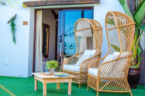 two wicker chairs and a table on a porch at Casona de Tao in Tiagua
