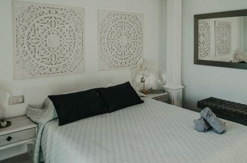 a bedroom with a bed with a black pillow on it at Casona de Tao in Tiagua