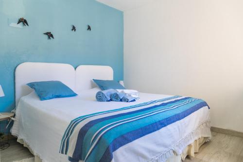a bedroom with a white bed with blue walls at 2 Bedroom house and Garden Lounge in Sintra
