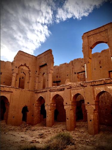 an old brick building with arches in the desert at Maison d'hôte ''J'' in Agdz