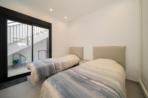 due letti in una stanza con finestra di Villa Camilla a Roda