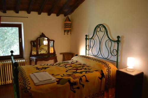a bedroom with a bed and a table and a mirror at Agri-Bio Podere Santa Palmira in Pomarance