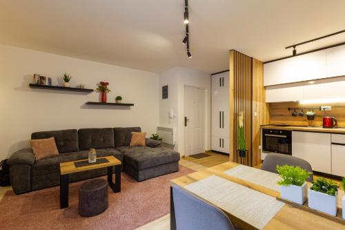 uma sala de estar com um sofá e uma mesa em Ema apartman - Zlatar em Nova Varoš