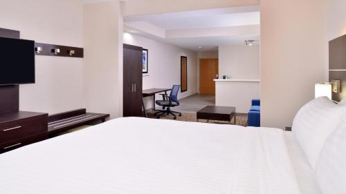 a hotel room with a bed and a desk at Holiday Inn Express Hotel & Suites La Place by IHG in Laplace