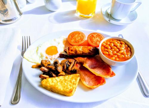 a plate of breakfast food with eggs bacon beans and toast at Lee House in Lynton