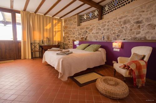 a bedroom with a bed and a chair in a room at O Canto da Terra in Pantón