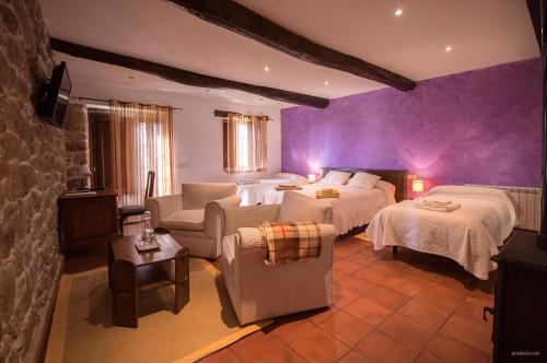 a bedroom with two beds and a living room with a couch at O Canto da Terra in Pantón