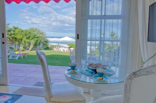 a dining room with a table and chairs and a window at Haus am Strand - on the Beach in Wilderness