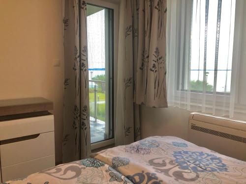 a bedroom with a bed next to a window at Part Royal Apartments in Keszthely