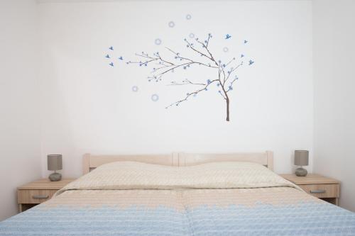 1 dormitorio con 1 cama con un árbol en la pared en Toto, en Lukovo Šugarje