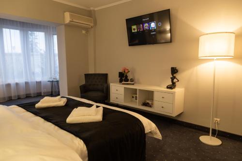 ファガラシュにあるCITADEL VIEW Apartmentのベッド1台、壁掛けテレビが備わるホテルルームです。