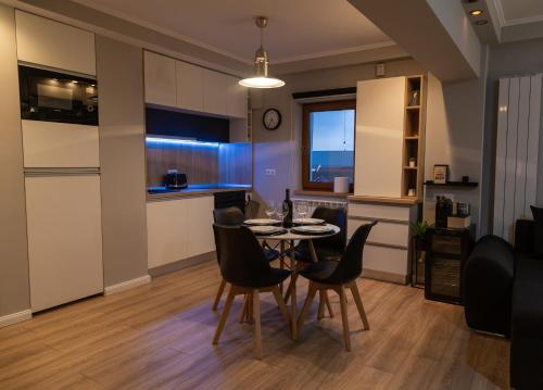 a dining room and kitchen with a table and chairs at CITADEL VIEW Apartment in Făgăraş