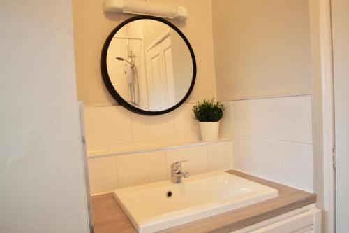 a bathroom with a sink and a mirror on the wall at Hambleton Road East in Catterick Camp