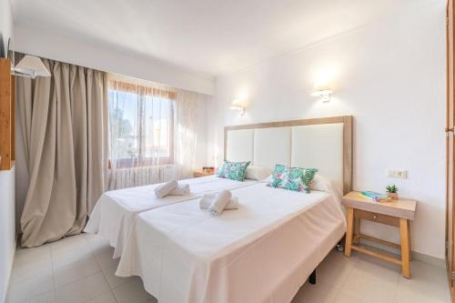 een slaapkamer met een groot wit bed en een raam bij Apartamento Felipe 2-5 in Cala d´Or