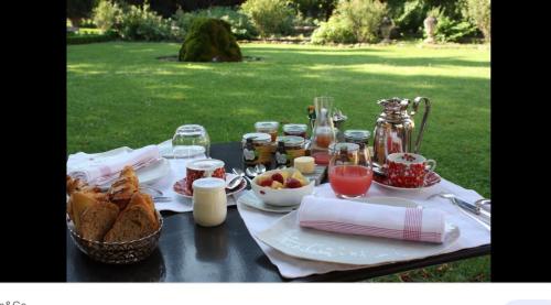 a picnic table with food and drinks and a basket of bread at Domaine de la Provençale in Saint-Didier-de-la-Tour