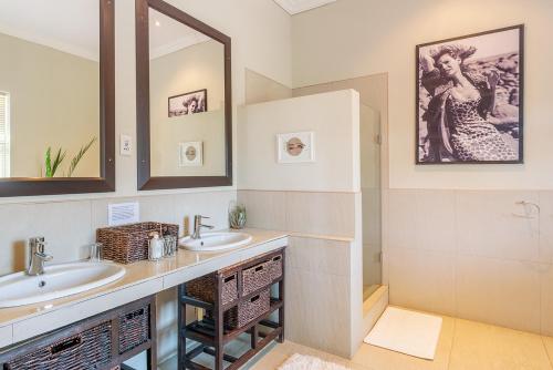 a bathroom with two sinks and a mirror at Guinevere Guest Farm in Tulbagh