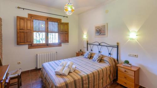 a bedroom with a bed with two towels on it at Cortijo El Olivar Órgiva by Ruralidays in Órgiva