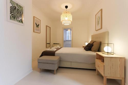 リスボンにあるAlfama Prestige by Homingのベッドルーム1室(ベッド1台、椅子、テーブル付)
