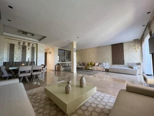 - un grand salon avec un canapé et une table dans l'établissement Villa golf prestigia marrakech, à Marrakech