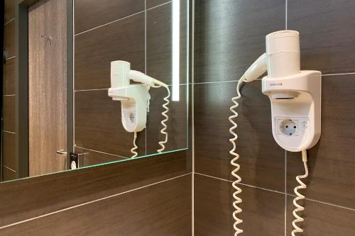 a bathroom with a phone on a wall at XO Hotel Inner in Amsterdam