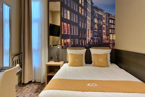a bedroom with a large bed and a wall with buildings at XO Hotel Inner in Amsterdam