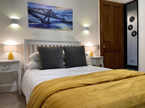 a bedroom with a large bed with a yellow blanket at Heart of George street / Oban / Argyll in Oban