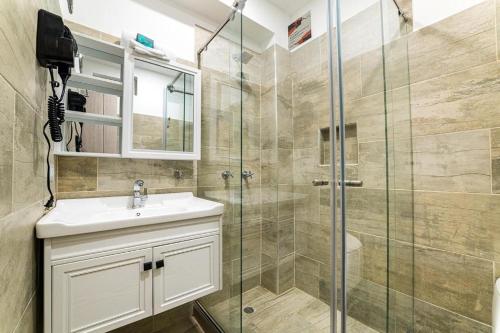 a bathroom with a sink and a glass shower at Basic Hotel Chipichape by Hoteles MS in Cali