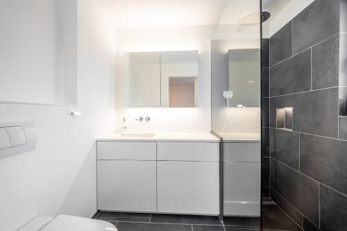 La salle de bains blanche est pourvue d'un lavabo et d'un miroir. dans l'établissement Casa Guarda Val 1, à Falera