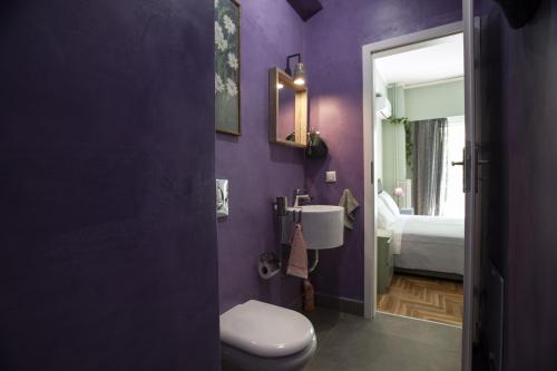 une salle de bains pourpre avec toilettes et lavabo. dans l'établissement Modern-Vintage apartment by Acropolis museum, à Athènes
