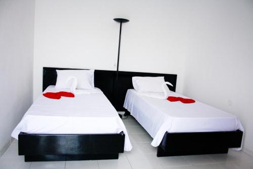 two beds in a room with red roses on them at Académico do Sal in Espargos