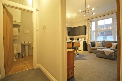 a living room with a kitchen and a living room with a couch at Lovely 1 Bed serviced apartment in Cambridgeshire in Ely
