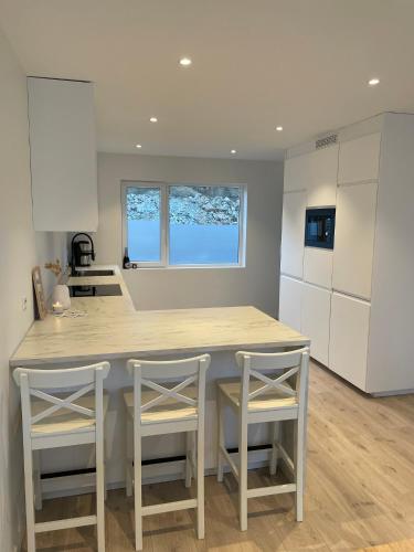 a kitchen with a large island with two stools at Strandferie på Sørlandet in Kristiansand