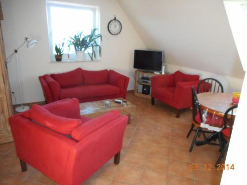 a living room with two red couches and a table at Sonnenblume in Landkirchen