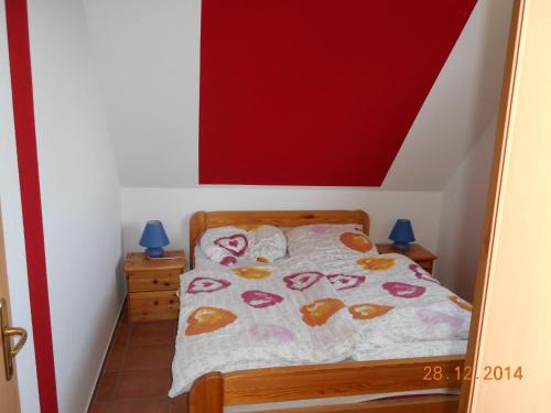 - une chambre dotée d'un lit avec un mur rouge dans l'établissement Sonnenblume, à Landkirchen