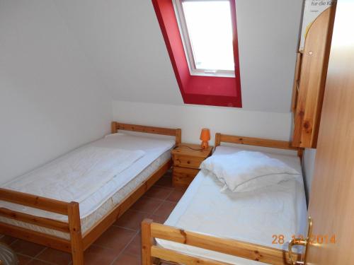 two beds in a room with a mirror and a window at Sonnenblume in Landkirchen
