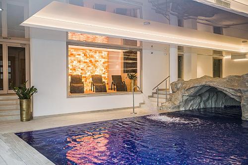a swimming pool with a waterfall in a house at Hotel Lubicz in Ustka