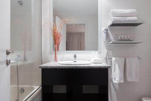 a bathroom with a sink and a mirror at Gran Hotel Fray Bentos in Fray Bentos