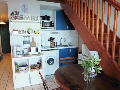 une cuisine avec une table et un évier, ainsi qu'un escalier. dans l'établissement 5RB14 Appartement vue mer et proche plage, à Collioure